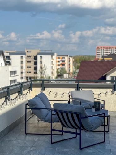 two chairs and a table on top of a roof at Skylark - Monaco Penthouse with Jacuzzi & Panoramic View in Braşov