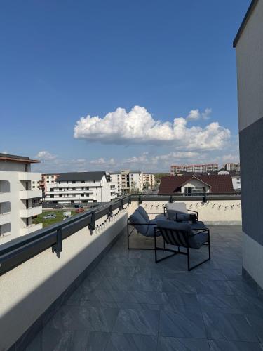 a balcony with a couch and chairs on a building at Skylark - Monaco Penthouse with Jacuzzi & Panoramic View in Braşov