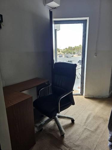 une chaise de bureau bleue assise devant un bureau dans l'établissement Brise de mer L'écume, à La Plaine