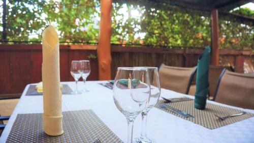 a table with two wine glasses and a candle on it at ATACO COUNTRY RESORT in Fort Portal