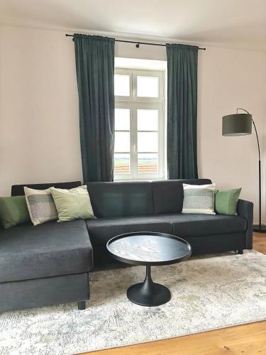 a living room with a blue couch and a table at betterplaces: Boutique Apartments - Frontenhausen in Dingolfing
