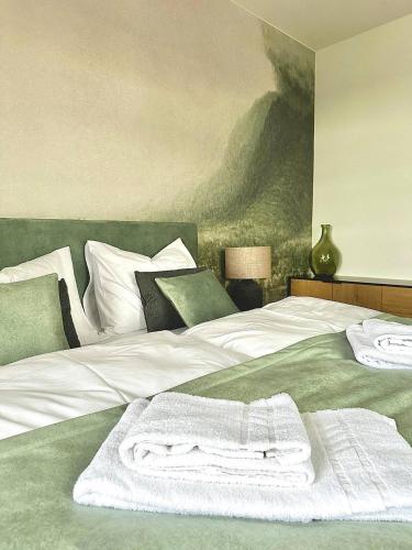 a bedroom with a bed with a white towel on it at betterplaces: Boutique Apartments - Frontenhausen in Dingolfing