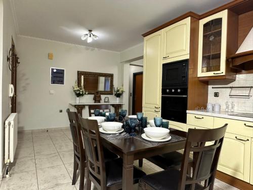 a kitchen with a wooden table and chairs in a kitchen at Eleni's Luxury Stay - Kos in Zipárion