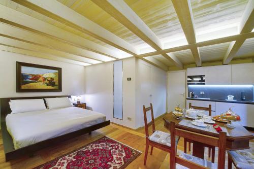 a bedroom with a bed and a table and a dining room at Le Bourg Charmant - Soleil d'été in Arvier
