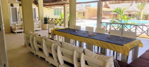 - une table et des chaises dans une chambre avec piscine dans l'établissement Ocean zuri villa, à Watamu