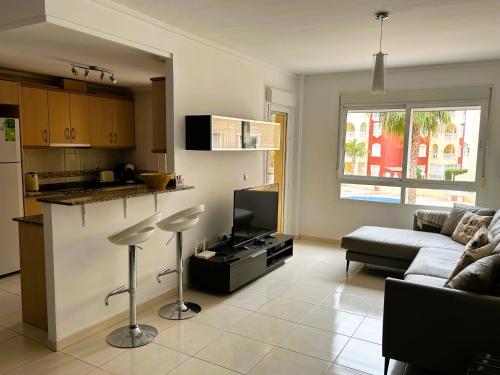 eine Küche und ein Wohnzimmer mit einem Sofa und einem Tisch in der Unterkunft Beautiful 3 bed, 2 bath modern apartment in Los Alcázares