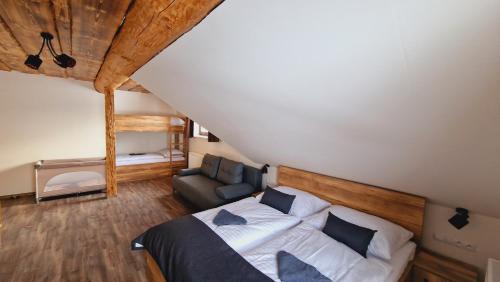 a bedroom with a bed and a chair in a attic at Zrub Poľana - Liptovská Mara in Ižipovce