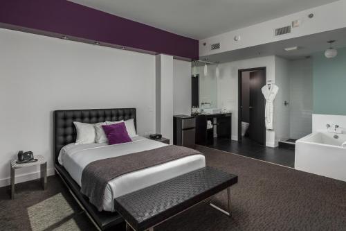 a bedroom with a large bed and a bath tub at Hotel Metro in London
