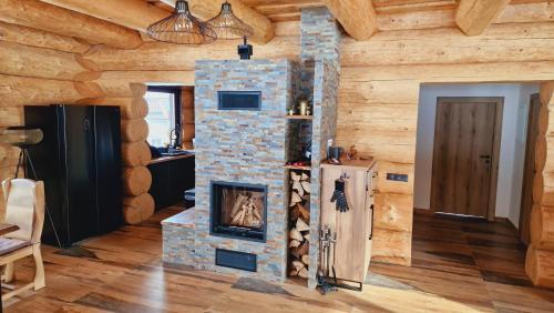 a room with a stone fireplace in a log cabin at Zrub Poľana - Liptovská Mara in Ižipovce