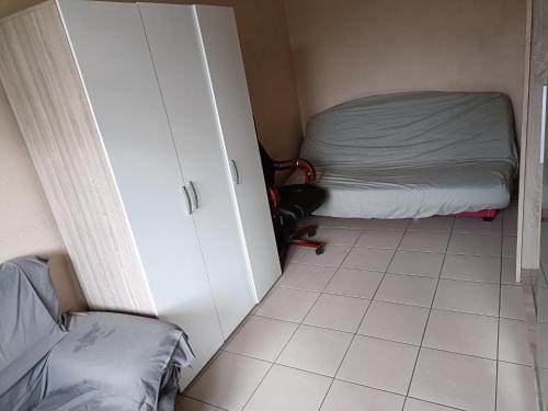 Cette petite chambre comprend un lit, une armoire et du carrelage. dans l'établissement Magnifique T2 avec double séjour, à Avignon