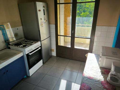 Il comprend une cuisine équipée d'une cuisinière et d'un réfrigérateur. dans l'établissement Magnifique T2 avec double séjour, à Avignon