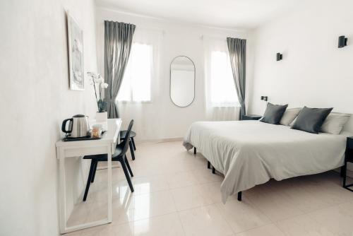 Habitación blanca con cama, escritorio y espejo. en Cà Zorzi - 2 minutes from Biennale & Canal view - APE G, en Venecia