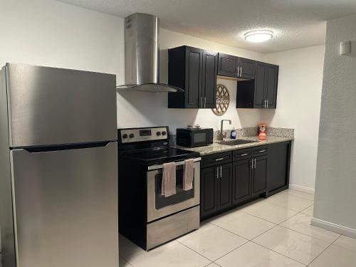 a kitchen with black cabinets and a stainless steel refrigerator at Fabulous downtown experience 3 mins away in Las Vegas