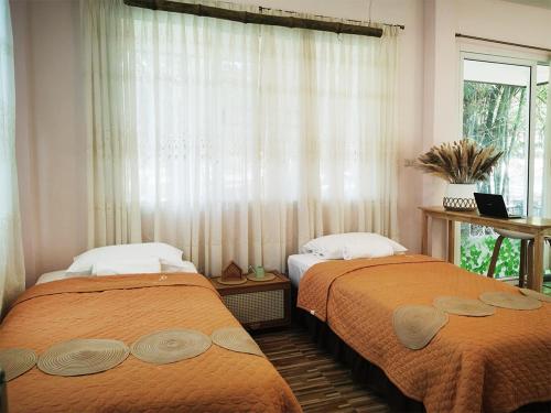 two beds in a room with a window at SN Garden in Songkhla