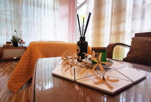 a room with a bed and a table with flowers on it at SN Garden in Songkhla