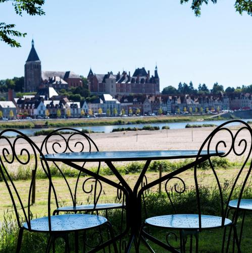 une table et des chaises avec vue sur une ville dans l'établissement mobil home o'hara, à Poilly-lez-Gien
