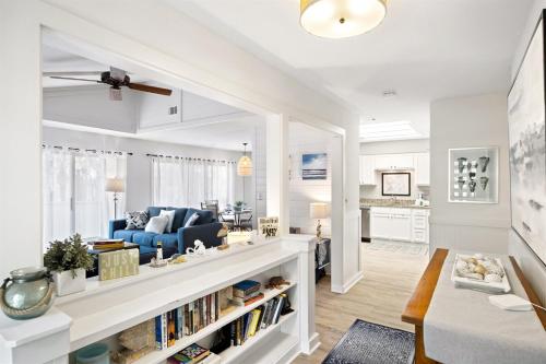 a white living room with a blue couch and a table at Beachwalk 158 in Hilton Head Island