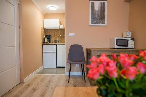 une petite cuisine avec une table et un four micro-ondes dans l'établissement Apartament Reset Ustroń Jaszowiec, à Ustroń