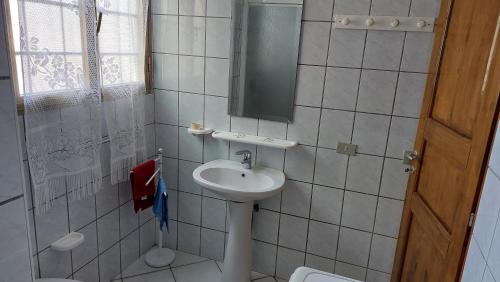 uma pequena casa de banho com um lavatório e um espelho em Appartamento 'il cortiletto' em Porto Ottiolu