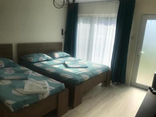 a bedroom with two twin beds and a window at Pensiunea Paradis Baile Herculane in Băile Herculane