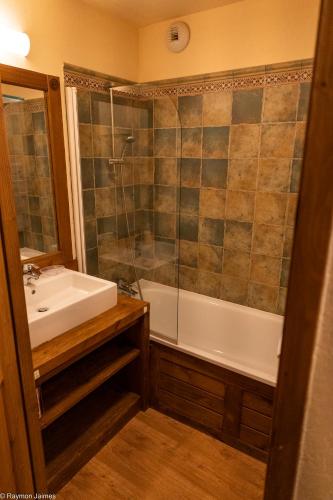 une salle de bain avec une baignoire, un lavabo et une douche dans l'établissement Apparts au Cœur de St-Lary - Piscine Chauffée et Sauna, à Saint-Lary-Soulan