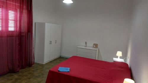 um quarto com uma cama vermelha e um cobertor vermelho em Appartamento 'il cortiletto' em Porto Ottiolu