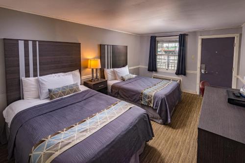 a hotel room with two beds and a table at Sunrise Inn Hershey in Hershey