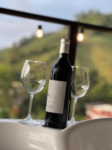 una bottiglia di vino e due bicchieri di vino su un tavolo di Ecovillage glamping Idilio a Llanitos