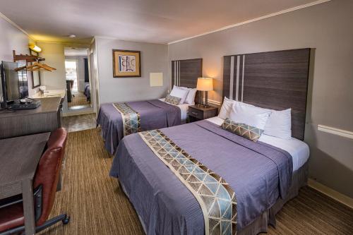 a hotel room with two beds and a desk at Sunrise Inn Hershey in Hershey