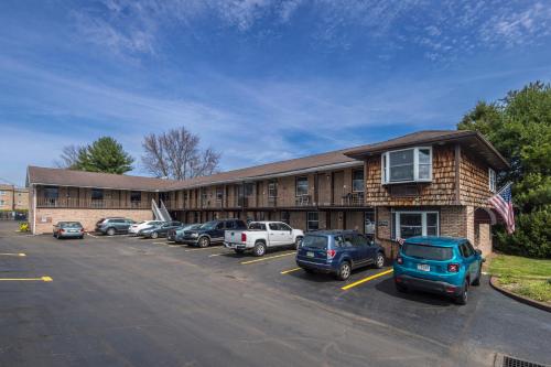 een groot gebouw met auto's geparkeerd op een parkeerplaats bij Sunrise Inn Hershey in Hershey