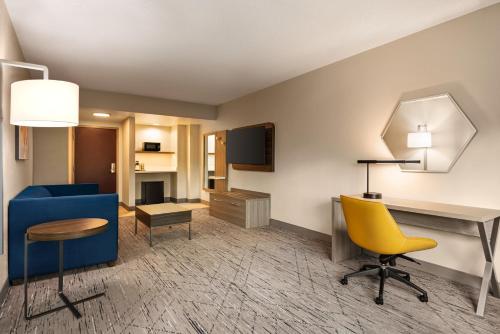 ティルマンズ・コーナーにあるHoliday Inn Express & Suites Mobile West I-10, an IHG Hotelのリビングルーム(青いソファ、黄色い椅子付)