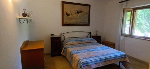 a bedroom with a bed in a room with a window at Casa in Maremma in Montemerano