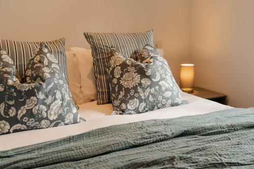 a bed with blue and white pillows on it at Fantastic Chester city centre location! Sleeps up to 4 in Chester