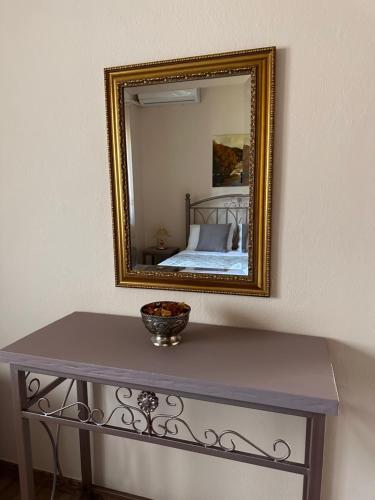 a mirror on a wall with a table and a bed at Kiwi Traditional House in Litochoro