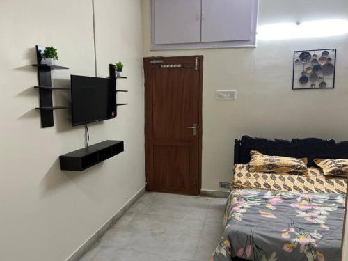 um quarto com uma cama e uma televisão na parede em Maruthi Villa 2BHK,Walkable to Beach em Visakhapatnam