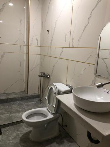 a bathroom with a white toilet and a sink at Hotel thái bảo in Thôn Mỹ Phước