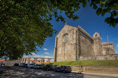 an old church with cars parked in front of it at 480 Liberdade Apartamento in Labruge