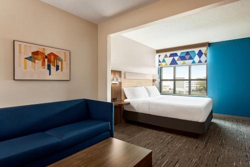 ティルマンズ・コーナーにあるHoliday Inn Express & Suites Mobile West I-10, an IHG Hotelのベッドとソファ付きのホテルルーム
