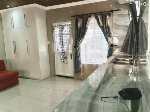 eine Küche mit einer Glasscheibe und einem Fenster in der Unterkunft P & T Guesthouses in Pietermaritzburg