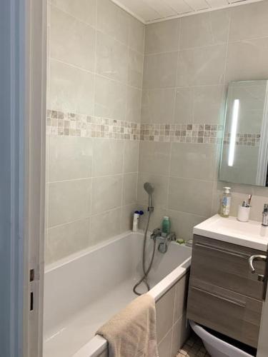 La salle de bains est pourvue d'une baignoire blanche, d'un lavabo et d'une baignoire. dans l'établissement Maison familiale - Marina de Talaris - Lac Lacanau, à Lacanau