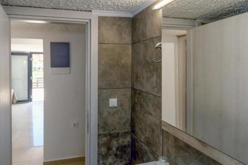 a bathroom with a shower with a toilet and a mirror at MARTAS HOUSE in Daratso