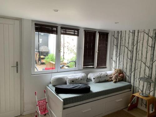 un ours en peluche assis sur un siège de fenêtre dans une pièce dans l'établissement Maison familiale - Marina de Talaris - Lac Lacanau, à Lacanau