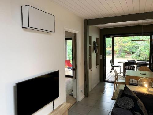 a living room with a flat screen tv on a wall at Maison familiale - Marina de Talaris - Lac Lacanau in Lacanau