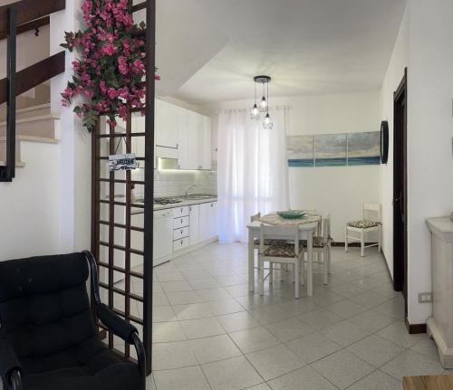 een keuken en eetkamer met een tafel en een vaas met bloemen bij Casa mare e relax in Pula