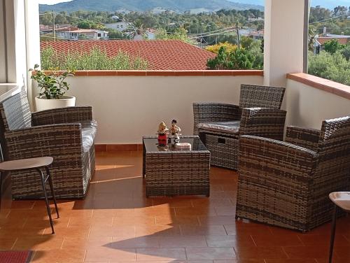 a patio with wicker chairs and a table with a view at Casa Pipere in Santa Lucia