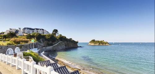 a beach with white fences and the ocean at Escale en bord de mer T3 au coeur de Saint-Quay in Saint-Quay-Portrieux
