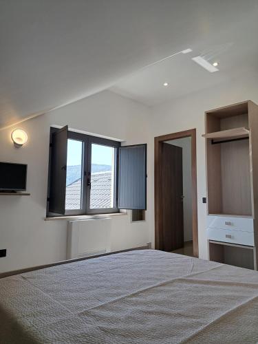 ein Schlafzimmer mit einem Bett und zwei Fenstern in der Unterkunft Villa Corina in Vaccarizzo Albanese