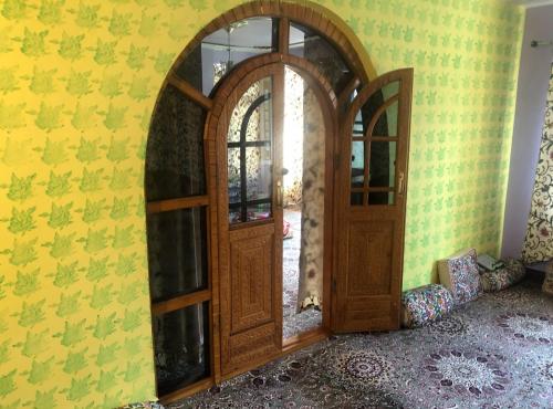 a wooden door in a room with a yellow wall at KaShMir ViBeS HoMeStAy Deluxe in Srinagar
