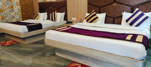 two large beds in a hotel room at Hotel Sunshine in Katra