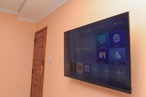einen Flachbild-TV, der an einer Wand hängt in der Unterkunft Tamwe ltd Airbnb &studios in Meru